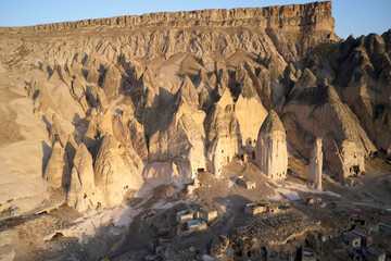 Archeology background of an ancient Cappadocia town. Cave dwellings in stone formations. Rural Cappadocia landscape.