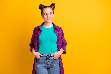 Photo of attractive charming teen lady two funny buns hold hands pockets good mood look side empty...