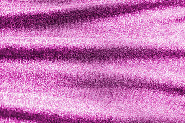 Colored raspberry pink magenta shiny fabric texture with folds. Surface background colors of the year 2021.