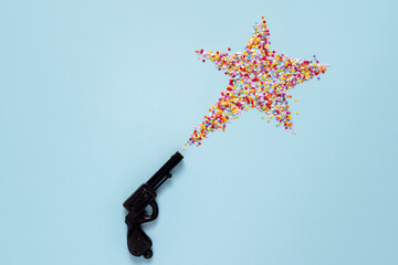 creative christmas concept: christmas star made from vintage toy gun on blue background