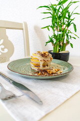 Pancakes with white chocolate and nuts on a plate, next to a knife and a fork. Breakfast concept. Eating at home.