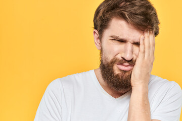 Obraz premium Man in white t-shirt emotions studio gestures with hands displeased facial expression yellow background