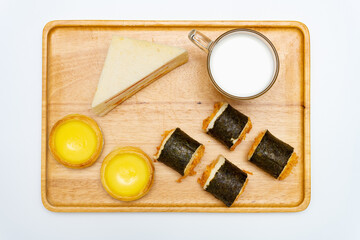 top view healthy breakfast with shredded pork seaweed rolls and sandwich and egg tarts and cup of milk