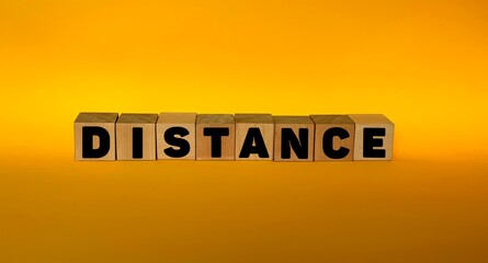 Distance on wooden blocks on a yellow background.The concept of social distance.