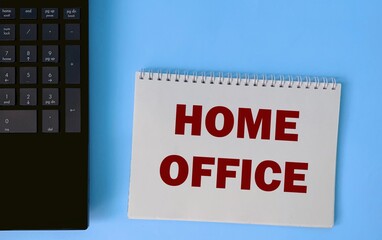 The word home office on a white Notepad on a blue background.The concept of working remotely during the coronavirus.