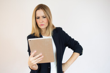 Fototapeta premium Businesswoman holding a tablet in her hands with doubtful gesture