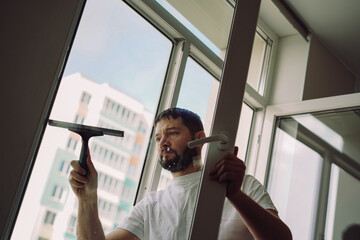 man washing window with small Squeegee. spring cleaning.