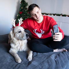 New Year's video calls. A young man with a dog looking at the phone