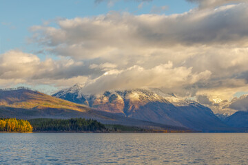 autumn landscape of majestic cloud enshrouded mountain in early morning with Lake McDonald in foreground, Glacier National Park, Montana