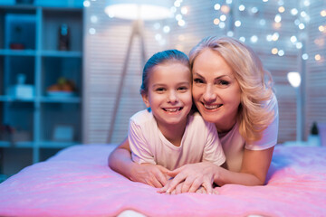 Grandmother and granddaughter are hugging at night