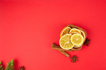 Dried orange slices in wooden bowl with cinnamon and anise.