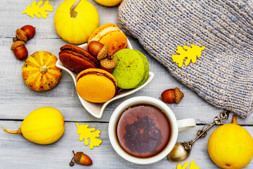 French macarons in autumn colors with cup of hot tea