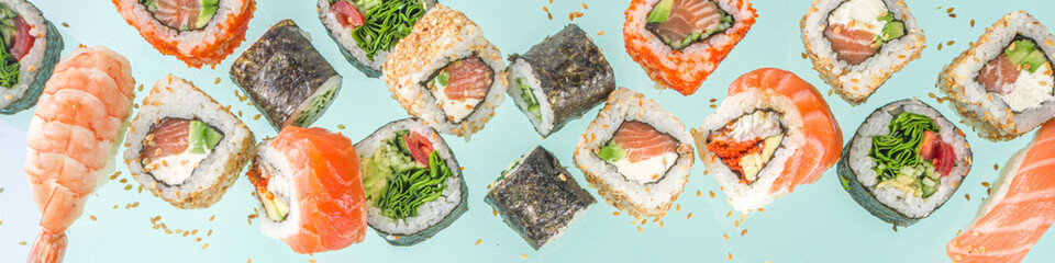 Flying sushi set with chopsticks. Various delicious japanese sushi, roll pieces and nigiri on light blue background