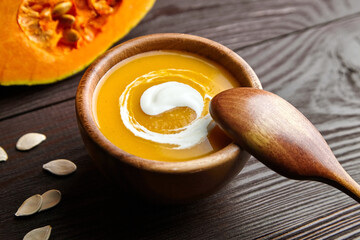 Autumn pumpkin soup in bowl with sour cream