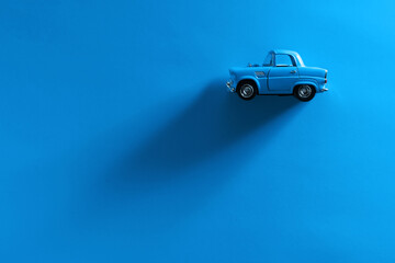 Blue toy car on a blue background.