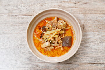spicy boiled slice fresh bamboo shoot with chicken and blood in coconut milk curry soup on bowl