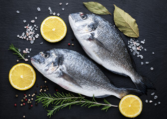 Fresh ready to cook raw gilt-head bream (dorade) fish with ingredients and seasonings.