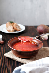 Garlic wholegrain donut and beetroot soup (borscht) with sour cream. Traditional ukrainian, russian soup on the wooden rustic table. Banner