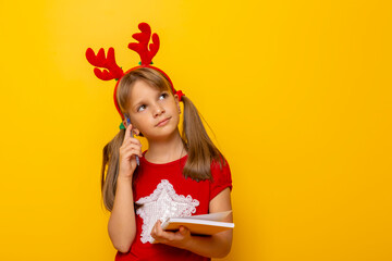 Little girl thinking while writing a letter to Santa
