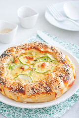 Open puff pastry zucchini pie sprinkled with poppy seeds and sesame seeds, selective focus