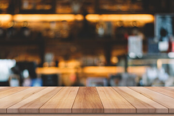 Empty wooden table top with lights bokeh on blur restaurant background.