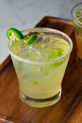 Margarita. Classic traditional Mexican cocktail. Made with Blanco tequila, fresh lime juice, agave syrup and orange juice. Served in salt rimmed tumbler over ice and garnished with a lime.