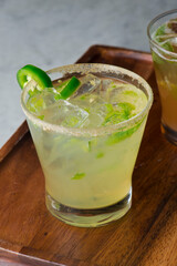 Margarita. Classic traditional Mexican cocktail. Made with Blanco tequila, fresh lime juice, agave syrup and orange juice. Served in salt rimmed tumbler over ice and garnished with a lime.