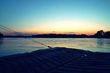 Barcaza de transporte fluvial al atardecer. Gabarra de carga en el delta del danubio a la puesta...
