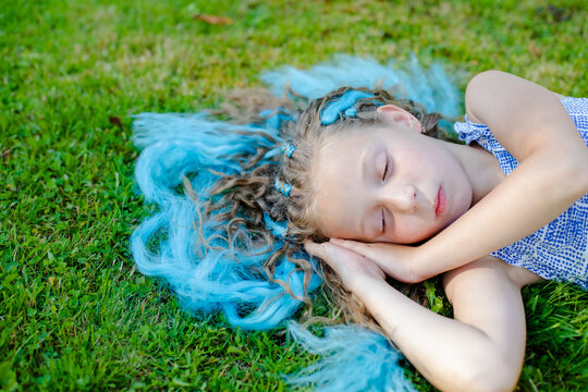 The Girl On The Lawn. Rest In Nature. Sleeping On The Meadow, To Dream. Stroking The Grass. Relaxation, Bliss, Rest. Sweet Sleep. Sweet Dreams.Kid With Closed Eyes Sleeping On The Grass