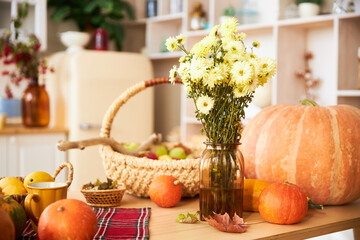 Autumn harvest - flowers, pumpkins, apples and berries on the wooden table of a beautiful wooden...