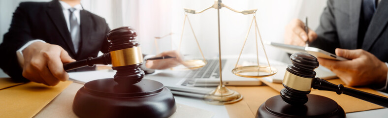 Business and lawyers discussing contract papers with brass scale on desk in office. Law, legal services, advice, justice and law concept picture with film grain effect