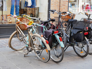 Fototapeta na wymiar Ferrara, Italy. Bicycles parked in front of a shop.