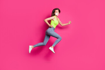 Fototapeta na wymiar Full body profile side photo of positive girl jump run fists wearing orange face mask isolated over pink color background