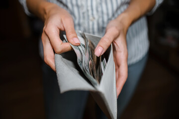 Woman counts money, close-up of a wallet with ruble banknotes. Selective focus, dark background