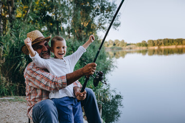 grandfather and his grandson fishing on the lake