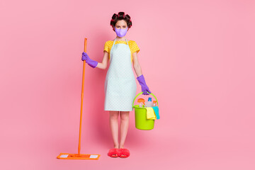 Full size photo positive wife hold bucket mop wear purple fabric face mask isolated pastel pink color background