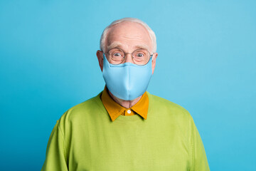 Photo of pensioner grandpa wear blue fabric face mask green pullover isolated blue color background