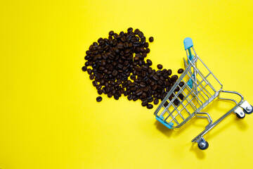 Shopping cart with coffee beans on yellow background. Shopping concept