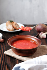 Garlic wholegrain donut and beetroot soup (borscht) with sour cream. Traditional ukrainian, russian soup on the wooden rustic table. Banner