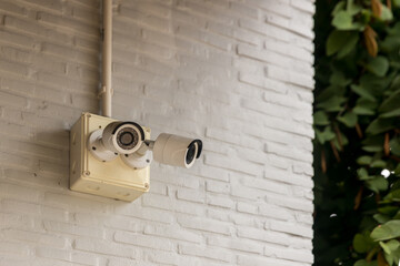 Security CCTV camera surveillance system outdoor of house. A blurred night city scape background. Modern CCTV camera on a wall. Equipment system service for safety life or asset.
