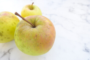Yellow Apple on the table close-up. Apple with spots, homemade apples from your garden.