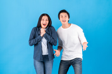 Asian couple man and woman are surprised / shocked / wonder standing over blue background