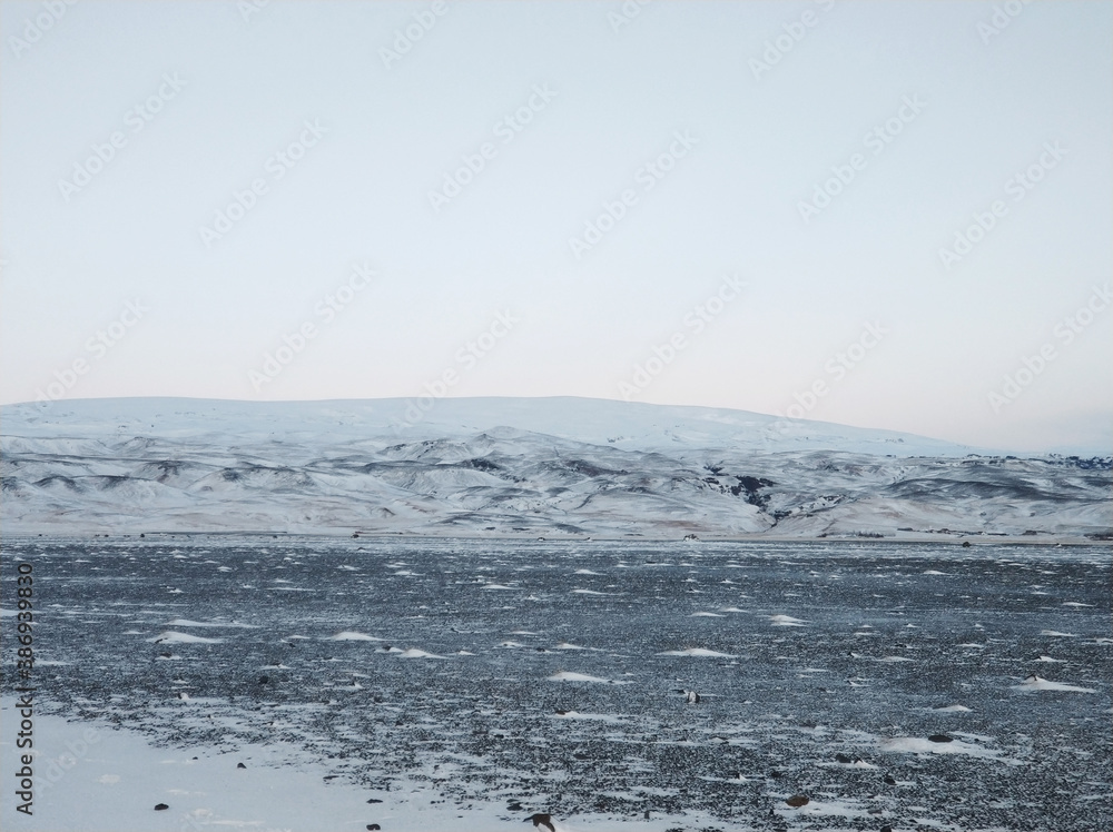 Wall mural Iceland's incredible fields and plains landscape in winter. The ground is covered with snow. Large spaces. The beauty of winter nature