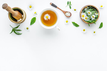 Top view of herbal tea in cup with herbs in bowls, top view