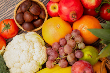Group vegetables and Fruits Apples, grapes, oranges, and bananas in the wooden basket with carrots,...