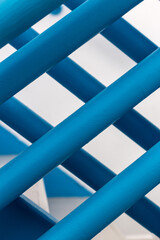 Bright blue color crosswise metal stair railings in an abstract form with white walls.
