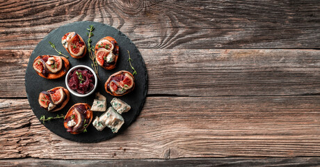 toast with caramelized onions, goat cheese, cream cheese, thyme, honey and figs. Figs with nut. blue cheese and honey. banner, catering menu recipe place for text, top view