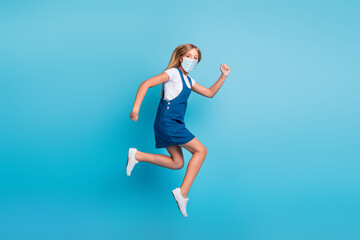 Fototapeta na wymiar Full size photo of funny blond girl jumping run wear flu mask t-shirt mini dress sneakers isolated blue color background