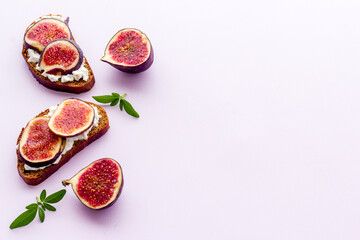 Toasted bread with figs, cheese and honey on table
