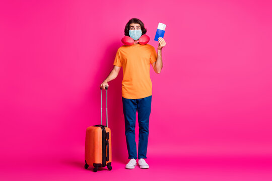 Full length photo of young man hold case tickets passport wear mask neck cushion t-shirt jeans isolated pink color background